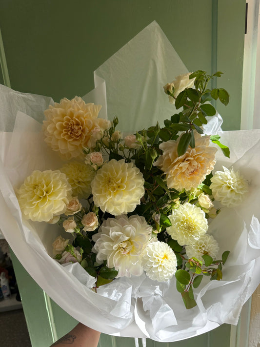 Elegant cream dahlia and rose bouquet wrapped in white paper, perfect for Brisbane flower delivery.